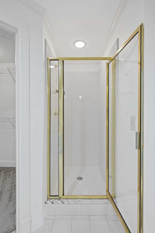 bathroom with ornamental molding, a stall shower, a walk in closet, and visible vents