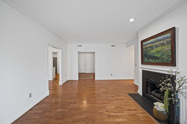 living room with a fireplace with flush hearth, ornamental molding, baseboards, and wood finished floors