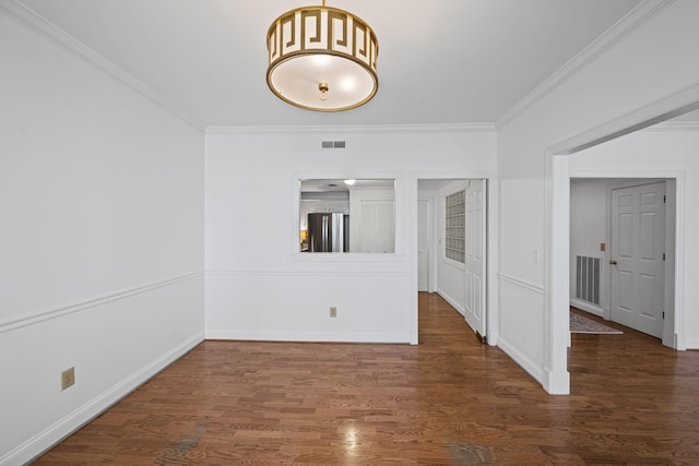 empty room featuring dark wood-style floors, visible vents, and crown molding