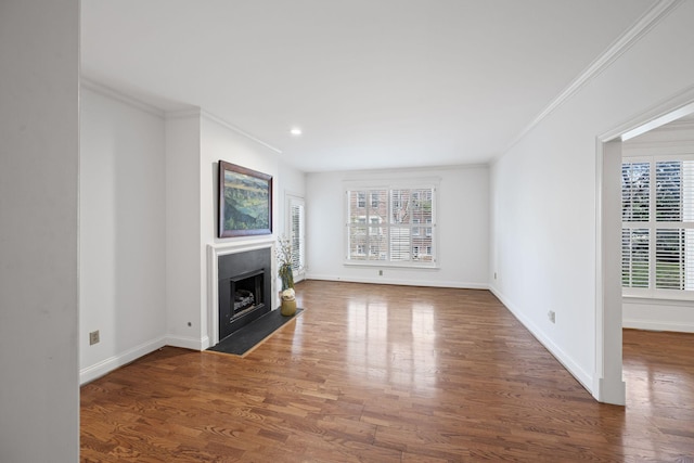 unfurnished living room with baseboards, a fireplace with flush hearth, ornamental molding, and dark wood-type flooring