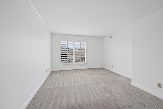 spare room with baseboards, ornamental molding, and light colored carpet