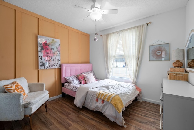 bedroom with dark wood-type flooring, a textured ceiling, and a ceiling fan