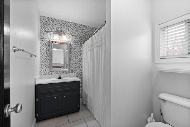 full bathroom featuring a textured ceiling, toilet, a shower with shower curtain, vanity, and wallpapered walls