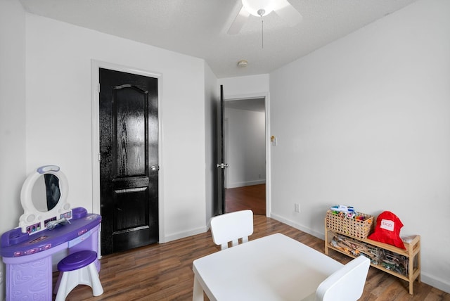 interior space with dark wood-style floors, a textured ceiling, a ceiling fan, and baseboards