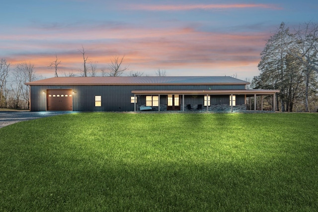 view of front of property with metal roof, a lawn, and driveway