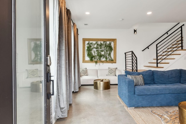 living area featuring visible vents, stairs, finished concrete floors, and recessed lighting