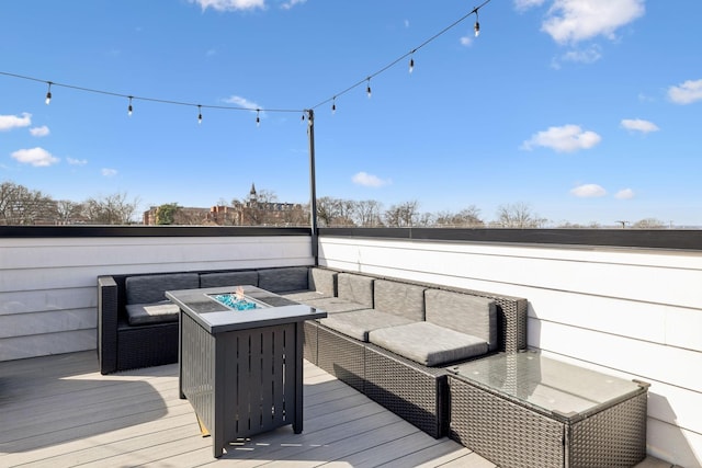 wooden terrace featuring an outdoor living space with a fire pit