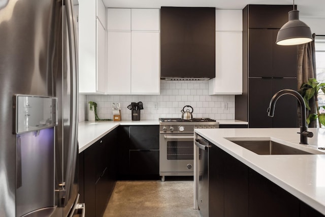 kitchen featuring light countertops, appliances with stainless steel finishes, modern cabinets, and decorative light fixtures