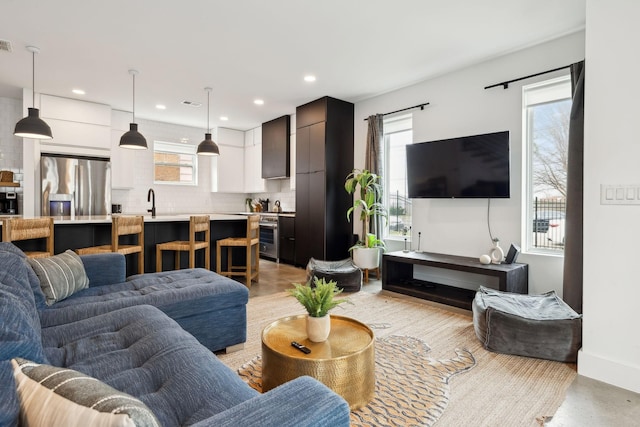 living room featuring recessed lighting, a healthy amount of sunlight, and visible vents