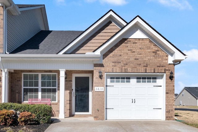 view of front of property with driveway, brick siding, an attached garage, and a shingled roof