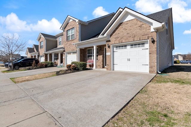 traditional home featuring an attached garage, driveway, and brick siding