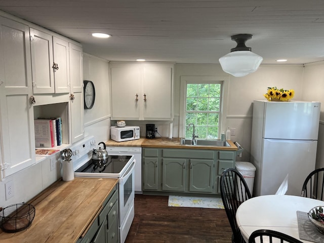 kitchen featuring dark wood-style floors, white cabinetry, a sink, butcher block countertops, and white appliances