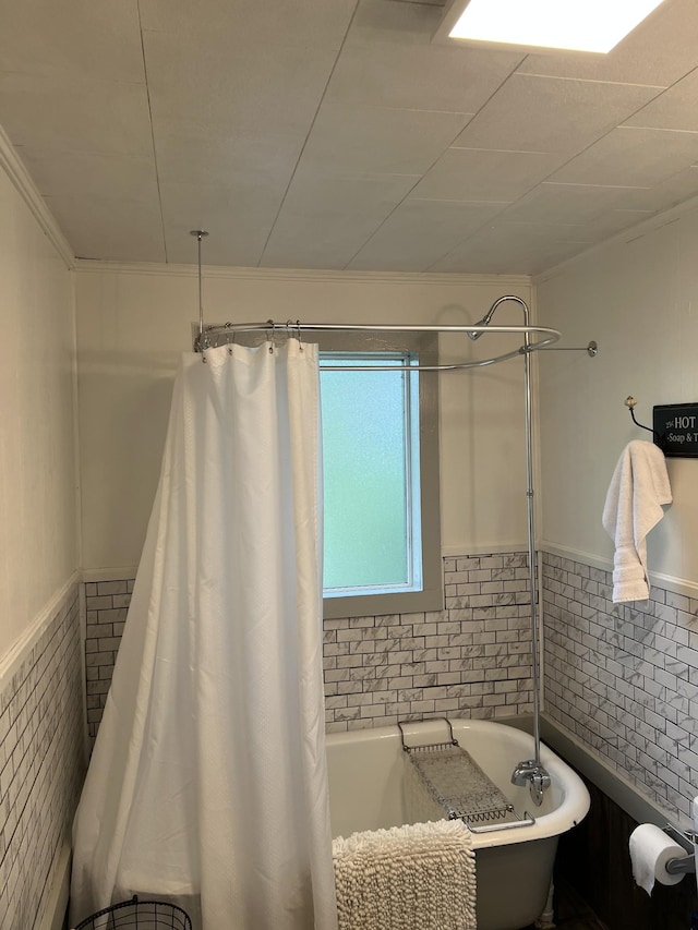 bathroom with wainscoting and shower / tub combo with curtain