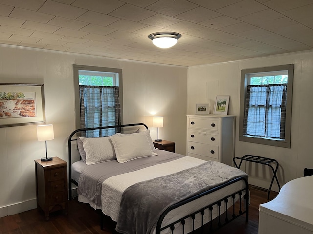 bedroom featuring crown molding and dark wood-type flooring
