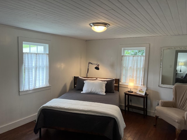 bedroom featuring wood ceiling, multiple windows, baseboards, and dark wood finished floors