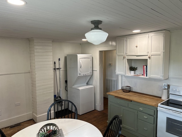 kitchen with dark wood-style floors, stacked washer and clothes dryer, electric range, white cabinets, and wood counters