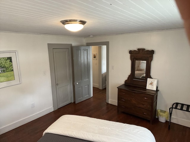 bedroom with dark wood-type flooring and baseboards
