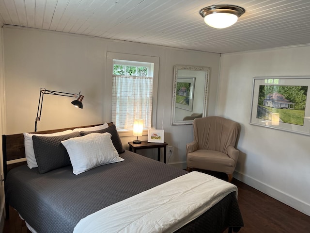 bedroom with dark wood-style floors, wooden ceiling, and baseboards