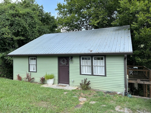 view of front of property featuring a front yard and metal roof