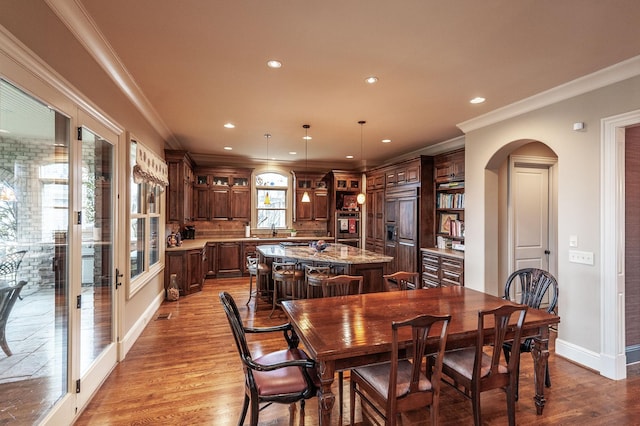 1225 Chloe Dr, Gallatin, TN 37066 - dining room with light wood-type flooring, arched walkways, and crown molding