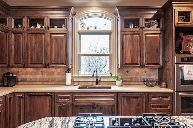 1225 Chloe Dr, Gallatin, TN 37066 - kitchen featuring dark brown cabinetry, a sink, light countertops, double oven, and backsplash