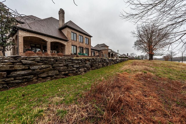 1225 Chloe Dr, Gallatin, TN 37066 - rear view of property featuring roof with shingles, a chimney, and brick siding