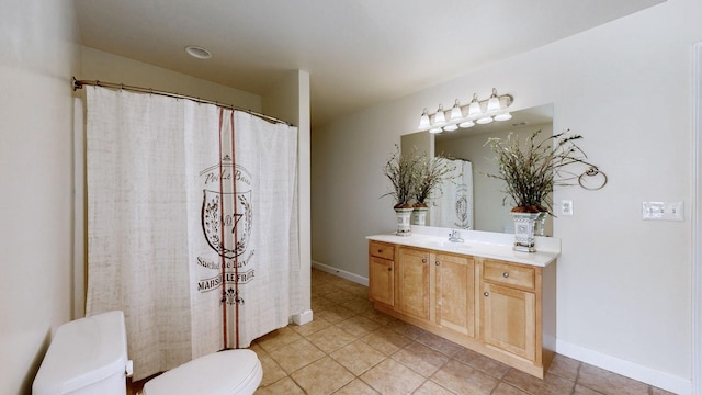 bathroom with tile patterned flooring, toilet, vanity, and baseboards