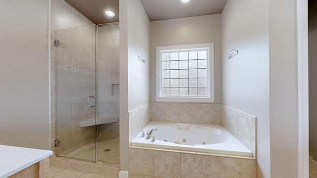 bathroom with a stall shower, tile patterned floors, a tub with jets, and recessed lighting