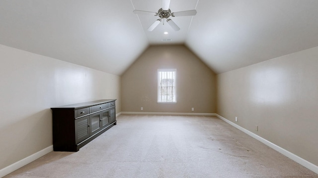 additional living space featuring lofted ceiling, visible vents, baseboards, and light colored carpet