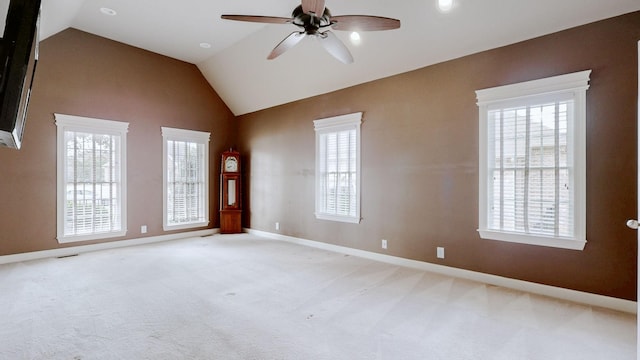 empty room with light carpet, vaulted ceiling, and a wealth of natural light