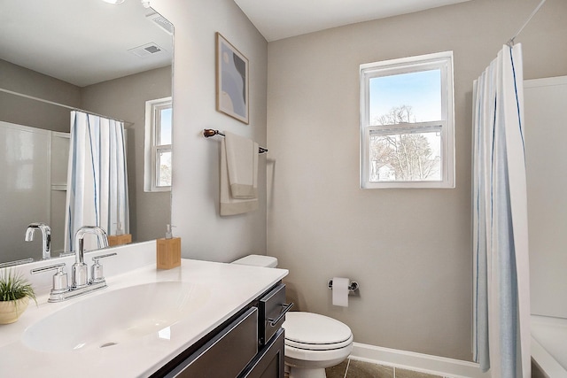 bathroom with a healthy amount of sunlight, baseboards, visible vents, and vanity