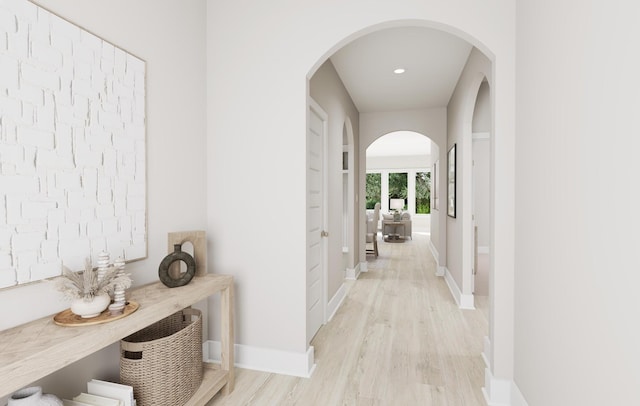 hallway with arched walkways, recessed lighting, light wood-style flooring, and baseboards