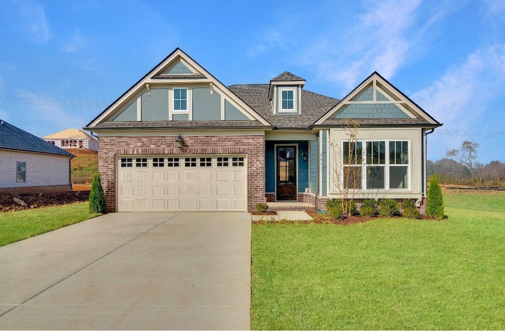 craftsman house featuring concrete driveway, a front lawn, and brick siding