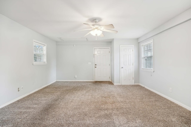 spare room featuring carpet, a ceiling fan, and baseboards