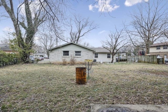 back of property featuring a yard and fence