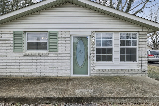 view of front facade featuring brick siding and a patio