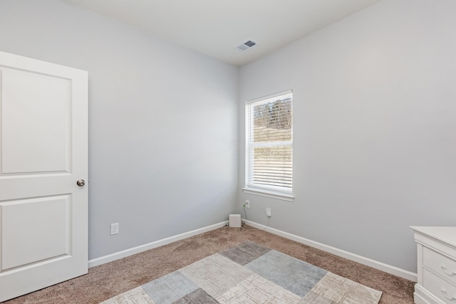 empty room with visible vents, light carpet, and baseboards