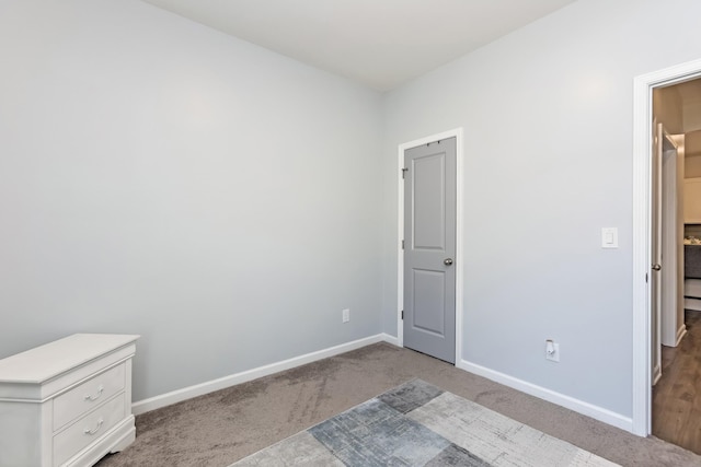 unfurnished bedroom featuring light carpet and baseboards