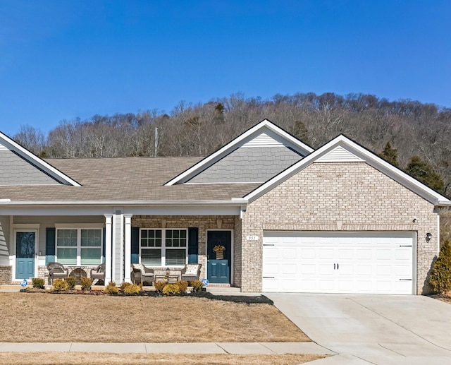 ranch-style home with a garage, covered porch, brick siding, and concrete driveway