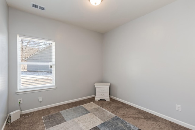 unfurnished room featuring dark colored carpet, visible vents, plenty of natural light, and baseboards