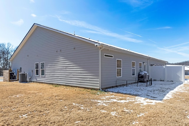 rear view of house featuring cooling unit and fence