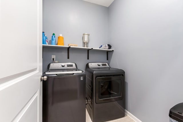 washroom with laundry area, independent washer and dryer, and baseboards