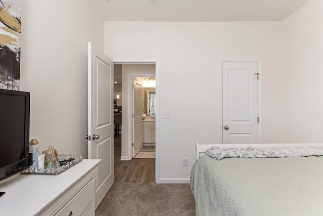 bedroom with dark colored carpet and baseboards