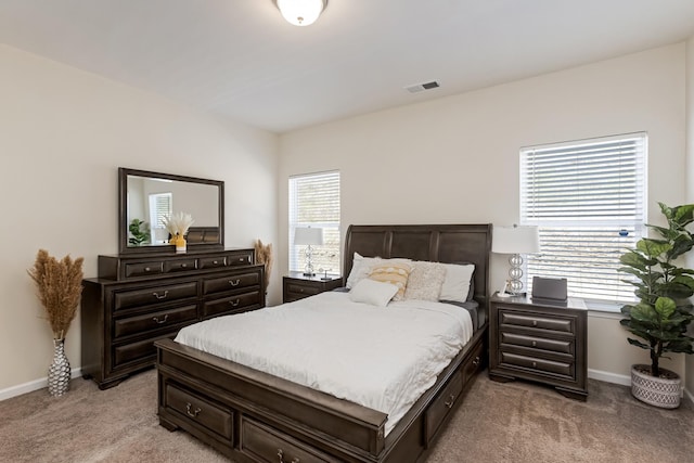 bedroom with light colored carpet, visible vents, and baseboards