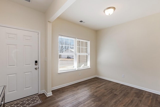 foyer entrance featuring dark wood-style flooring, visible vents, and baseboards