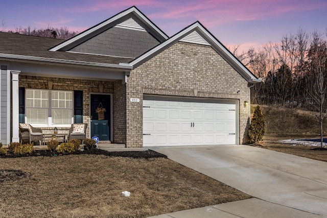 ranch-style home featuring an attached garage, covered porch, brick siding, driveway, and roof with shingles