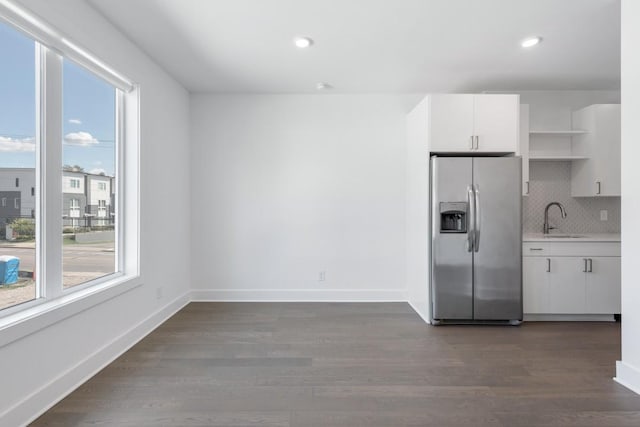 kitchen with open shelves, light countertops, white cabinets, a sink, and stainless steel fridge