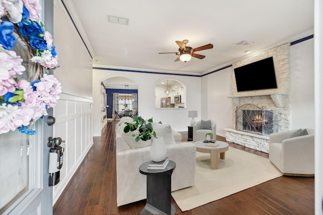 living room featuring visible vents, arched walkways, and crown molding