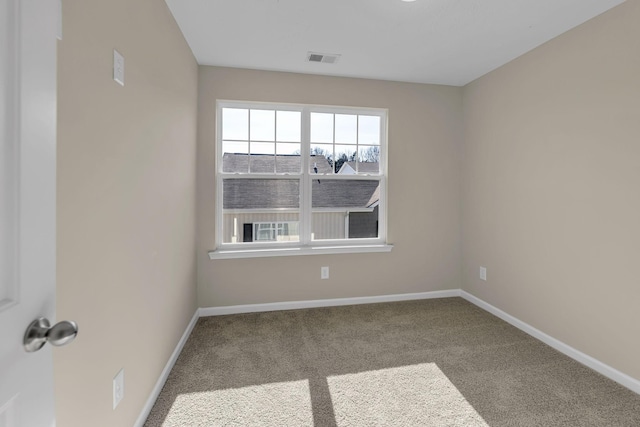 carpeted empty room featuring visible vents and baseboards