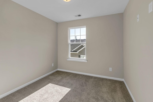 carpeted spare room featuring baseboards and visible vents